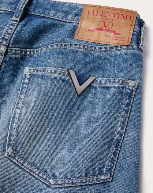 Valentino PANTALÓN DE DENIM CON DETALLE DE V METÁLICA